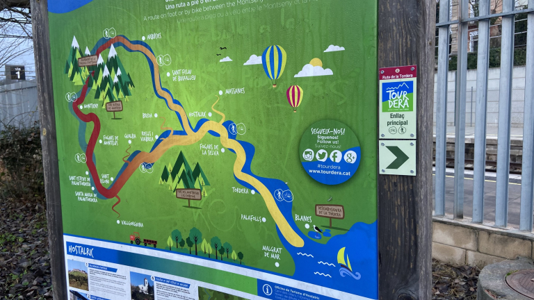 Foto: Tourdera. Senyalització entre l'estació de tren d'Hostalric i la Plaça dels Bous.